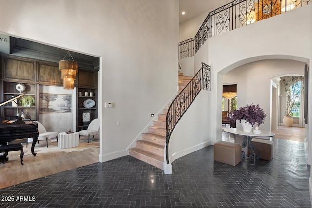 stairs with a towering ceiling and built in shelves