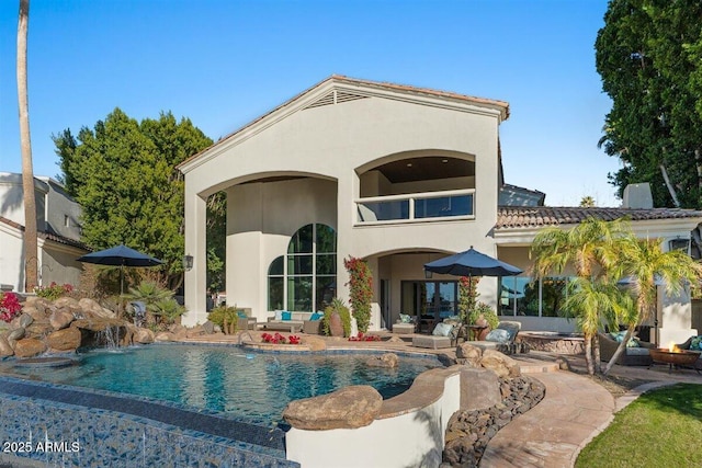 rear view of property with a fire pit and a patio