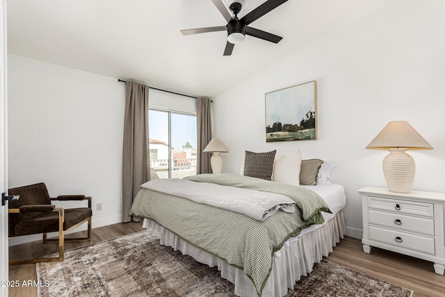 bedroom featuring lofted ceiling, baseboards, ceiling fan, and wood finished floors