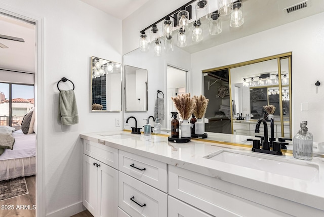 ensuite bathroom with ensuite bathroom, visible vents, a sink, and double vanity