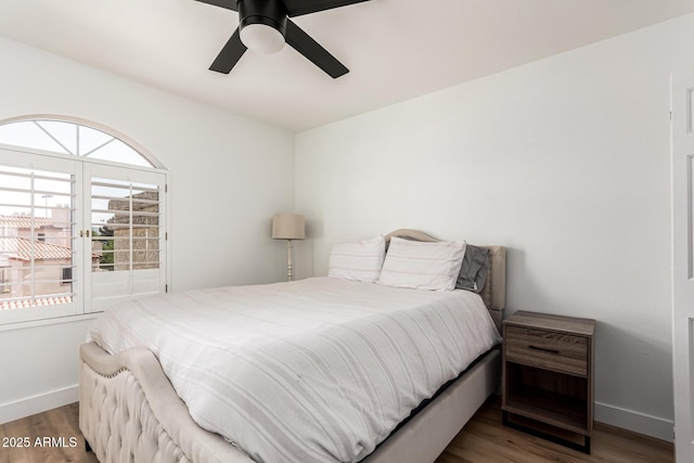 bedroom with ceiling fan, baseboards, and wood finished floors