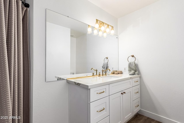 bathroom featuring baseboards, vanity, and wood finished floors
