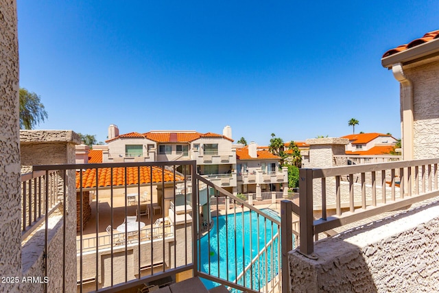 exterior space with a balcony, a residential view, and a community pool