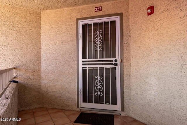 entrance to property with a balcony and stucco siding