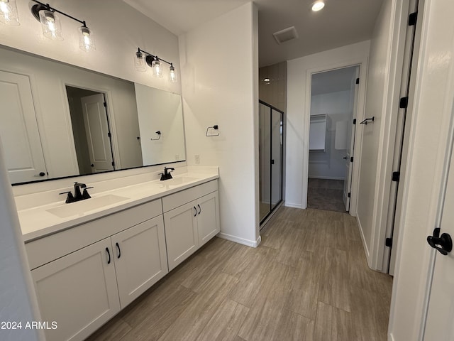 bathroom with hardwood / wood-style floors, vanity, and walk in shower