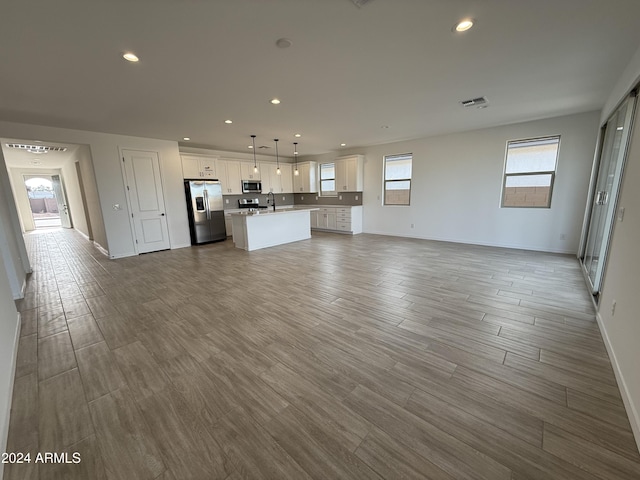 unfurnished living room featuring hardwood / wood-style floors and sink