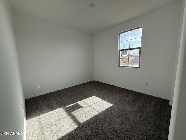 unfurnished room with dark carpet