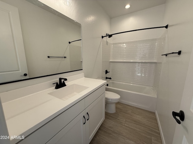 full bathroom featuring hardwood / wood-style floors, vanity, toilet, and shower / washtub combination