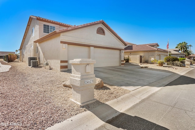 mediterranean / spanish-style house with a garage and central AC