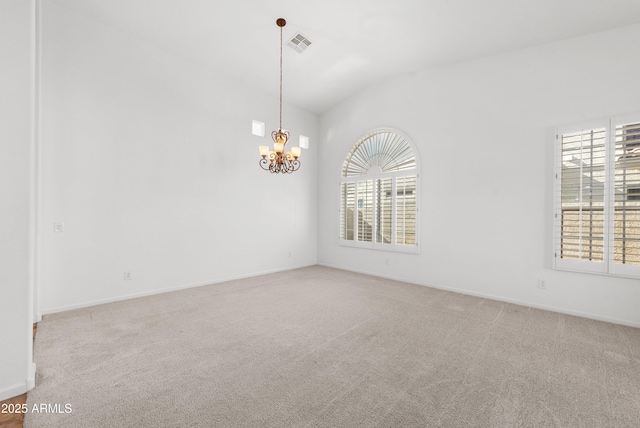 carpeted spare room with vaulted ceiling and a chandelier