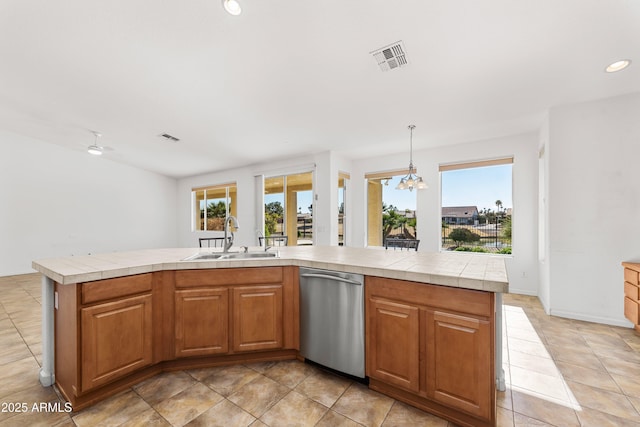 kitchen with a kitchen island, stainless steel dishwasher, tile counters, and sink