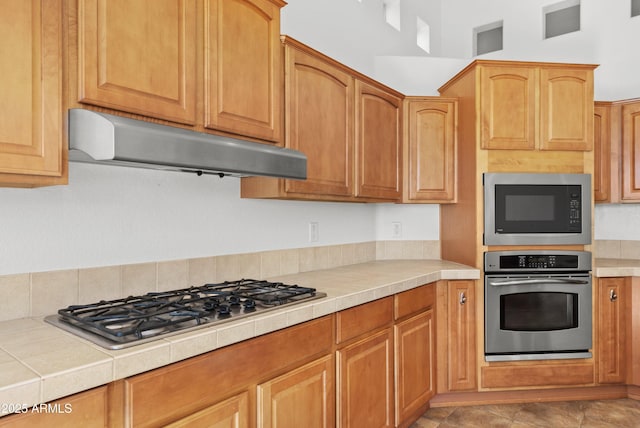 kitchen featuring stainless steel appliances and tile countertops