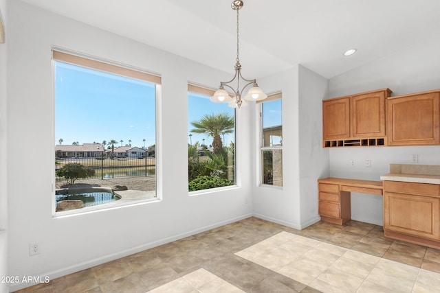 kitchen with built in desk, pendant lighting, an inviting chandelier, and vaulted ceiling