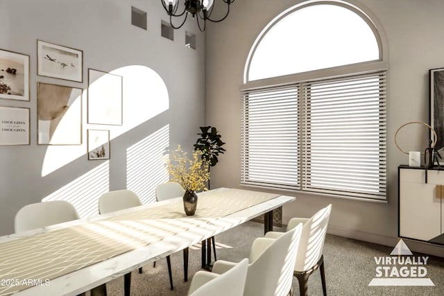 carpeted dining area featuring a healthy amount of sunlight and a notable chandelier