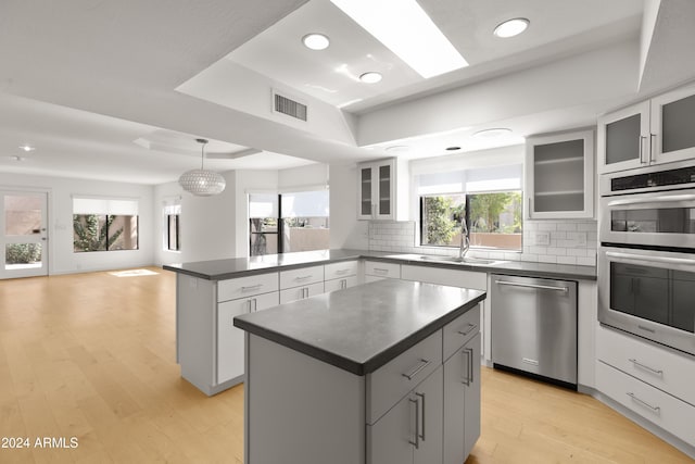 kitchen with tasteful backsplash, sink, stainless steel appliances, and a center island