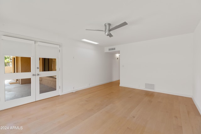 spare room featuring ceiling fan, light hardwood / wood-style floors, and french doors