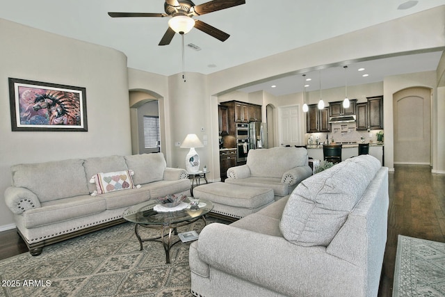 living room featuring dark wood-type flooring and ceiling fan