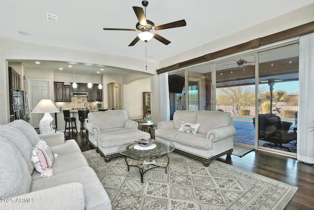 living room with dark wood-type flooring and ceiling fan