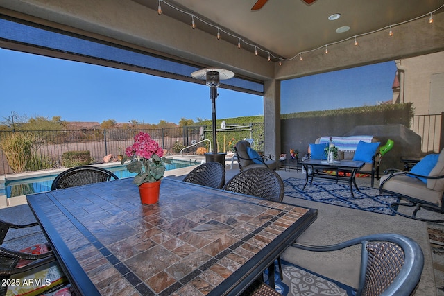 view of patio with a fenced in pool and ceiling fan