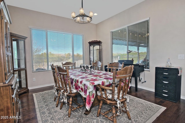 dining room with dark hardwood / wood-style flooring and a chandelier