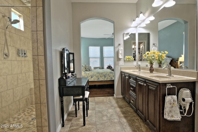 bathroom with ceiling fan, vanity, and tiled shower