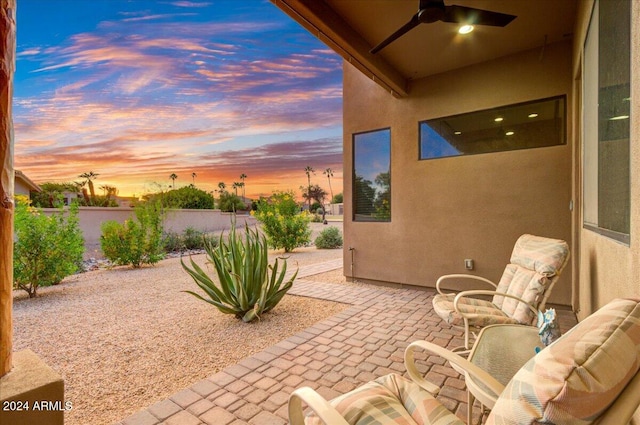 patio terrace at dusk featuring ceiling fan