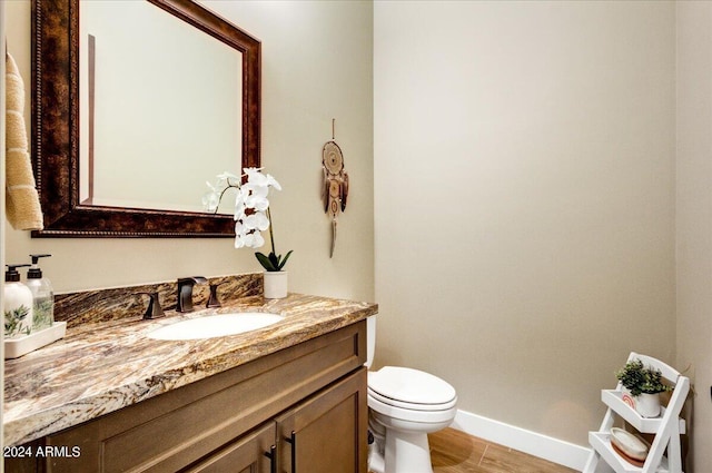 bathroom featuring toilet, vanity, and hardwood / wood-style floors