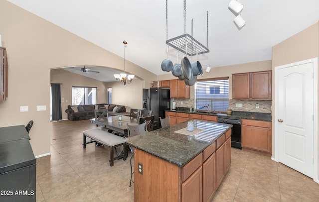 kitchen featuring black appliances, brown cabinetry, a sink, and a center island