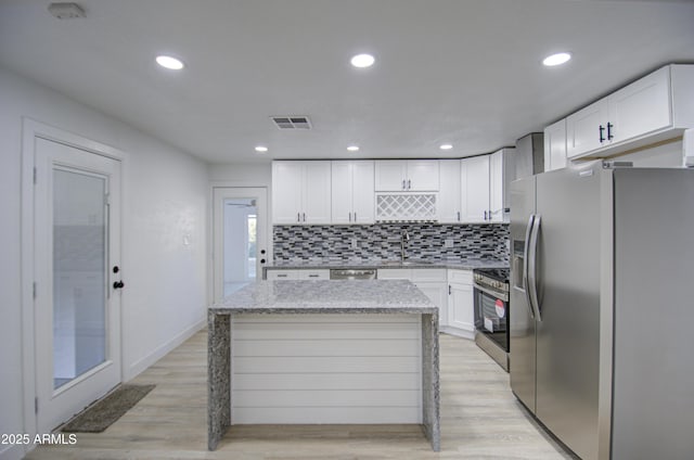 kitchen featuring white cabinetry, sink, stainless steel appliances, and a center island