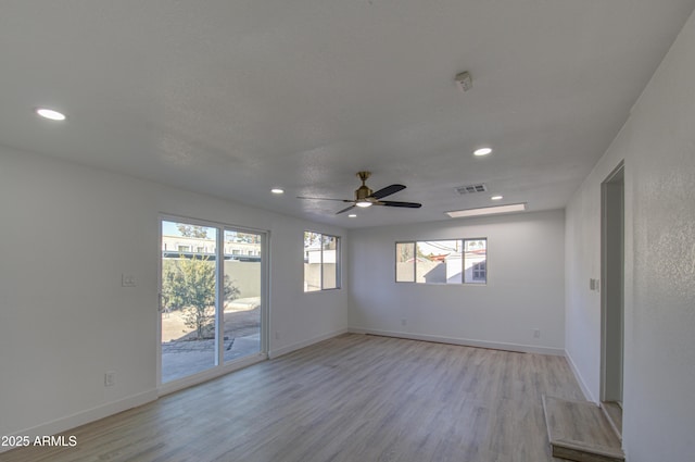 spare room with ceiling fan and light wood-type flooring