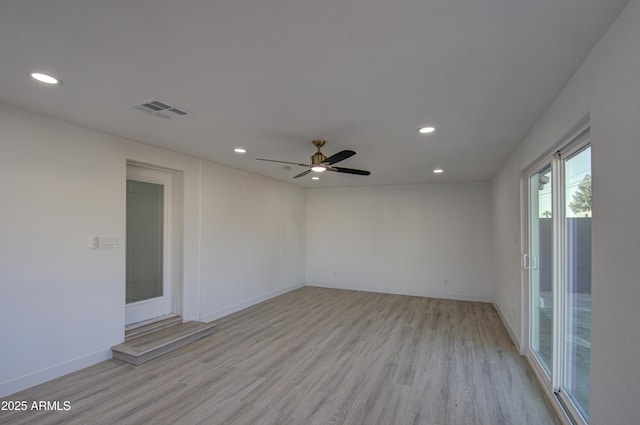 empty room with ceiling fan and light hardwood / wood-style floors