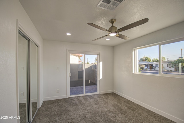 carpeted empty room featuring ceiling fan and a textured ceiling