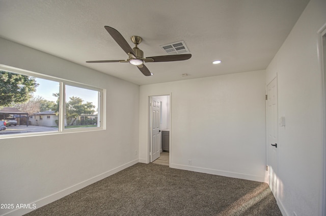 unfurnished bedroom featuring ceiling fan, ensuite bath, carpet, and a textured ceiling