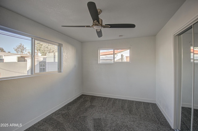 unfurnished room featuring dark colored carpet and ceiling fan