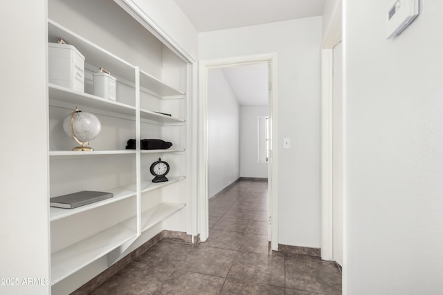 hallway featuring dark tile patterned flooring