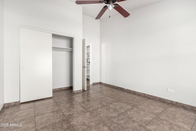 unfurnished bedroom with a closet, ceiling fan, and tile patterned flooring