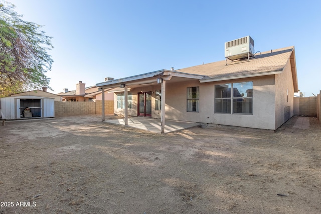 back of property featuring a patio area, central air condition unit, and a storage shed