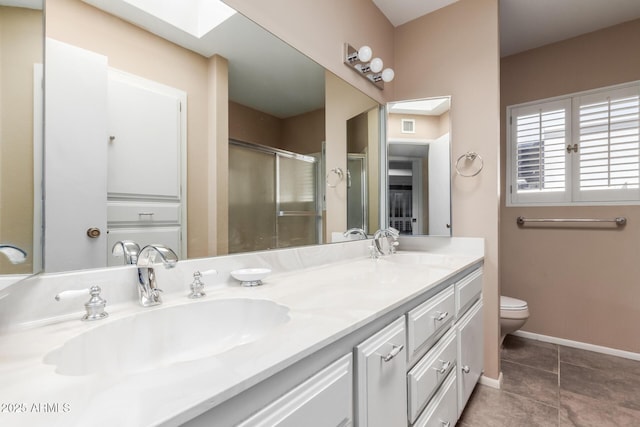full bathroom featuring a stall shower, a skylight, tile patterned floors, toilet, and double vanity