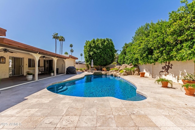 view of swimming pool featuring ceiling fan, a patio, and a fenced backyard