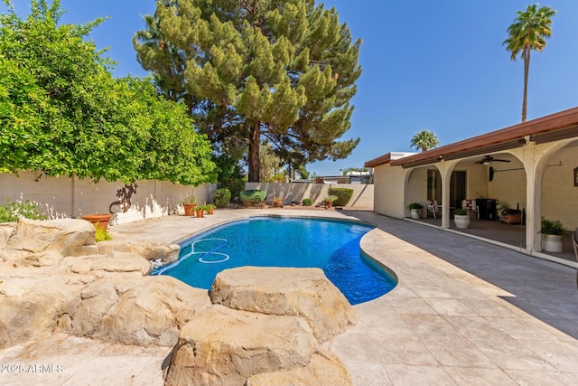 view of swimming pool with ceiling fan, a fenced backyard, and a patio