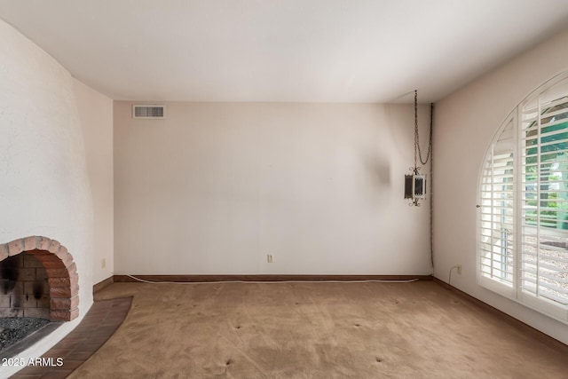 unfurnished living room featuring carpet, baseboards, and a brick fireplace
