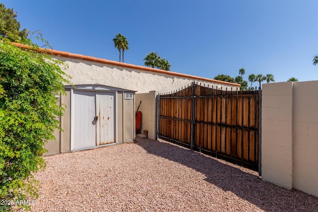 gate with a storage shed, an outbuilding, and fence
