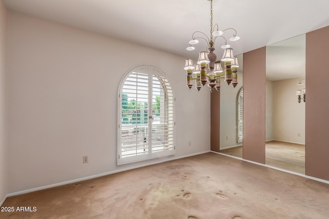 carpeted spare room with baseboards and a chandelier