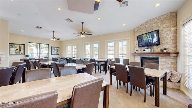 carpeted dining area featuring a fireplace and ceiling fan