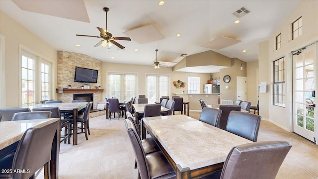 dining space featuring plenty of natural light, a fireplace, and vaulted ceiling