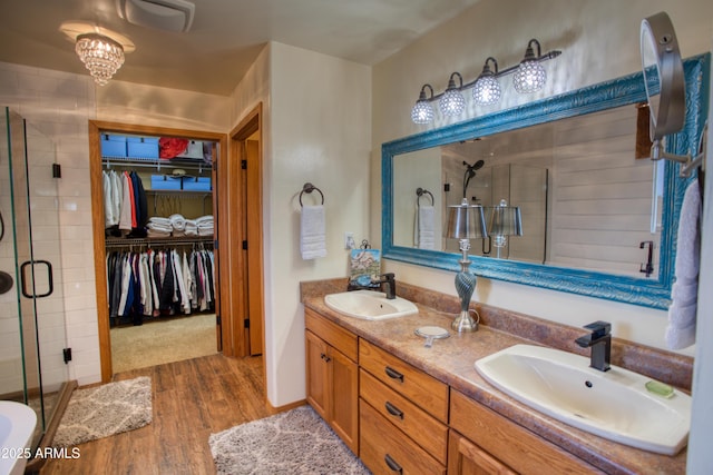 1420 S Haystack Rd, Taylor, AZ 85939 - full bathroom featuring a stall shower, double vanity, wood finished floors, and a walk in closet