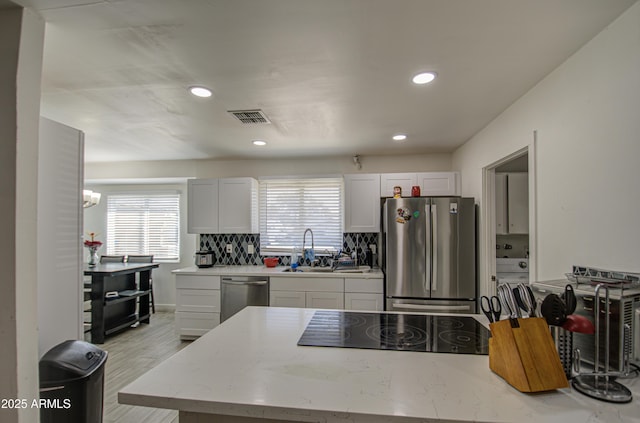 kitchen featuring stainless steel appliances, recessed lighting, visible vents, backsplash, and a sink