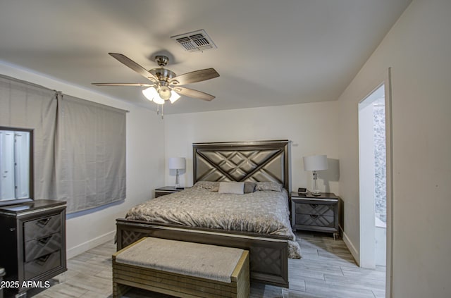 bedroom with light wood-style flooring, a ceiling fan, visible vents, and baseboards