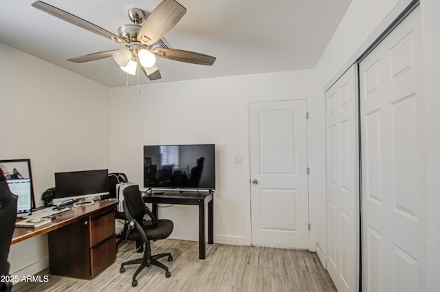 office space featuring light wood finished floors, a ceiling fan, and baseboards