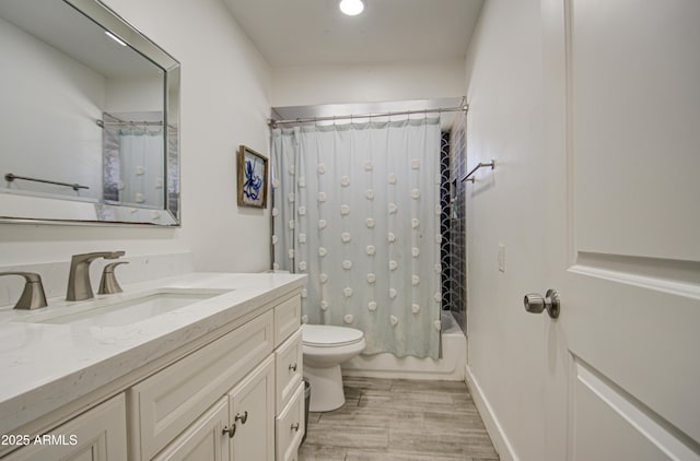 bathroom featuring wood finished floors, shower / bath combo with shower curtain, vanity, and toilet